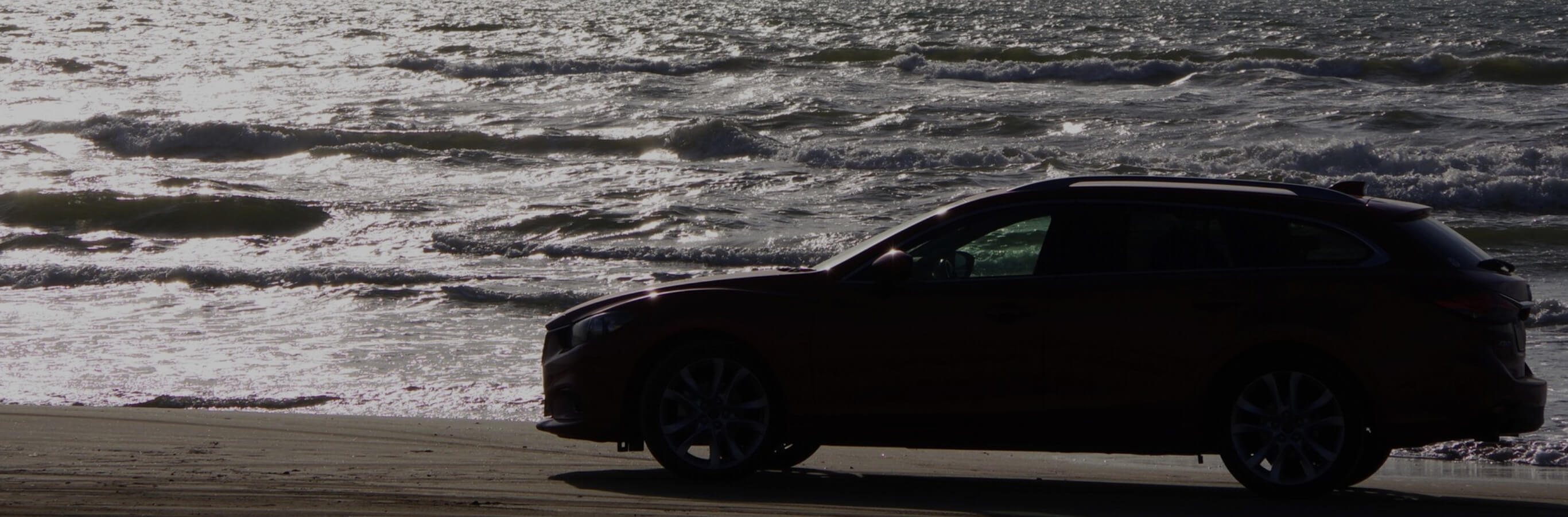 車が海辺を走っている写真